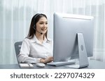 Small photo of Asian call center with headset and microphone working on her laptop. Female operator provide exceptional customer service. Supportive call center agent helping customer on inquiry. Enthusiastic