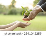 Small photo of Businessman handing plant or sprout to young boy as eco company committed to corporate social responsible, reduce CO2 emission and embrace ESG principle for sustainable future.Gyre