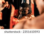 Small photo of African American Black boxer punching at trainer or coach wearing punching mitts as boxing bag training equipment in the gym. Strength and stamina training for professional boxing match. Impetus