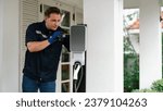 Small photo of Qualified technician install home EV charging station, providing maintenance service for electric vehicle's battery charging platform at home. EV car technology for residential utilization. Synchronos