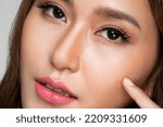 Small photo of Closeup portrait of ardent young girl with healthy clear skin and soft makeup looking at camera and posing beauty gesture. Cosmetology and beauty concept.
