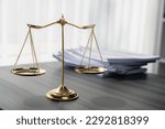 Small photo of Shiny golden balanced scale and pile of legal paper on desk in lawyer office as concept justice and legal symbol. Scale balance for righteous and equality judgment by lawyer and attorney. equility