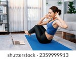 Small photo of Asian woman in sportswear doing crunch on exercising mat as home workout training routine. Attractive girl engage in her pursuit of healthy lifestyle with online exercise training video. Vigorous