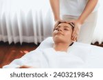 Small photo of Caucasian woman enjoying relaxing anti-stress head massage and pampering facial beauty skin recreation leisure in dayspa modern light ambient at luxury resort or hotel spa salon. Quiescent
