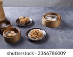 Small photo of The Arrangment of various dim sum in bamboo steamer with chinese bun, pao, bao zi, steamed dumpling, shumai on table in chinese restaurant. Hongkong dim sum or chinese dim sum.