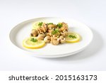 Small photo of Fresh top view whelks's cook or sea snails in a white plate, piece of lemon ,persil on white background.Food marine gastropod simple various in asia, europe kitchen, seafood concept. Selective focus.
