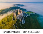 Aerial panoramic view of the Spiš Castle, Slovakia, in the morning sunlight with foggy background