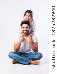 Small photo of Loving Indian daddy embracing cute little adorable daughter sitting over lap or piggyback - concept showing love, care, closest person, fathers day