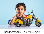 Indian small kid playing or repairing a toy motor bike or minibike