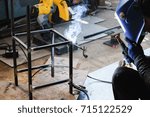 Small photo of Industrial worker welding metal steel to make chair. Flash burn, ultraviolet light, sparks, infrared light effect, technician use welding mask to protect the eyes.