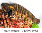 Small photo of Grill Tilapia African Style - whole grilled Tilapia smothered in spices and herbs.
