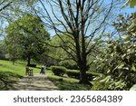 Small photo of Atlanta GA USA: March 30, 2023 – Visitor pushing b aby in stroller walks along beautiful treed grounds of Carter Presidential Center in Atlanta Georgia. Jimmy Carter is 39th President of USA.