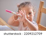 Small photo of Little girl playing iwth invisible ink and coloring book