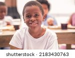 Small photo of Portrait of an African American boy looking at the camera. Garifuna boy having a good time with his siblings or friends at a beach restaurant.
