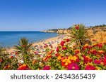 Colorful beach with flowers in Armacao de Pera, Algarve, Portugal