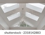Small photo of Minimal Bright Modern Skylight Vaulted Ceiling with Silver Metal Double Box Chandelier in Luxury Interior