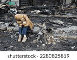Small photo of A girl next to a house destroyed by the war. War in Ukraine. Ukrainian refugees. Child in the ruins of his house destroyed by the war. Peace concept