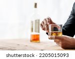 Sad depressed addicted drunk guy, Alone asian man drinker alcoholic sitting at bar counter with glass drinking whiskey.