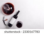 Small photo of Decanter, glass and bottle with red wine on white background. Flat lay