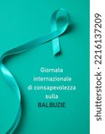 Small photo of the text international stuttering awareness day written in italian and an aquamarine awareness ribbon supporting those who stutter, on an aquamarine green background