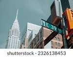 Small photo of New York City, US - May 16, 2023: An East 39th Street sign, in the intersection with Lexington Avenue, in Midtown Manhattan, in New York, United States, with the famous Chrysler Building on the left