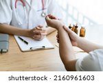 Small photo of Orthopaedic doctor doing physical examination in the patient with wrist pain at the clinic. Pain from tendonitis and sport injury. Medical and physical therapy concept.