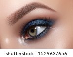 Small photo of Closeup Macro of Woman Face with Blue Eyes Make-up. Fashion Celebrate Makeup, Glowy Clean Skin, perfect Shapes of Brows. Shiny Simmer and Rouge