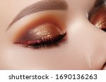 Small photo of Closeup Macro of Woman Face with Gold glitter Eyes Make-up, bright red liner. Fashion Celebrate Makeup, Glowy Clean Skin, perfect Shapes of Brows. Shiny Simmer and metalic eye shadows
