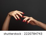 Elegant female hands with bright manicure. Square nails with red gel polish. Luxury fashion style of brilliants jewelry