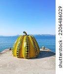 Small photo of Naoshima, Japan - 11.05.2017 : Yayoi Kusama’s iconic Yellow pumpkin sculptures stands by Miyanoura Port Naoshima island town Japan’s Seto Inland Sea