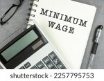 Minimum wage text on note pad with calculator.