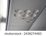 Small photo of Airplane passenger air conditioning flowing hole which is fixed on the seat overhead dashboard. Control buttons on the personal panel in the ceiling of airliner- light, steward call button and fan.