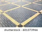 Texture of gray and yellow patterned paving tiles on the ground of street, perspective view. Cement brick squared stone floor background. Concrete paving slab flagstone. Sidewalk pavement pattern.