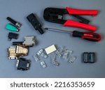 Small photo of Hand crimp tool for crimping of the round terminals and small heap of blue insulated terminals on a white background