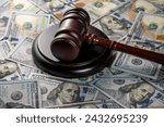 Small photo of Wooden judge gavel, soundboard with US 100 dollar bills on the background, close up. Finance and justice concept