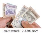 Small photo of Hands counting stack cash Serbian dinar different cost, recalculation banknotes. Parsimony, savings, home finance. Isolated on white. Close up.