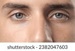 Small photo of Person open beautiful blue eyes close up and look camera. Face portrait. 30s man opening eyelid. Eye sight gaze. Male model see clearly. Blue iris lens. Guy stare closeup