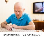 Worried elderly man measuring himself oxygen saturation