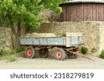 Small photo of Agricultural trailer with slurry tank stands in front of old farm wall