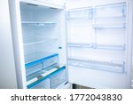 Refrigerator. Open door of an empty fridge. Household appliances in the store. Electrical equipment and household goods. Kitchen appliances in the mall.