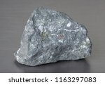 Small photo of Specimen of mineral stone magnetite (lodestone) on gray background.