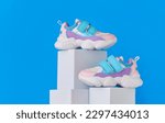 Small photo of Baby sneakers, child sport shoes pair on blue background. Fashion kids outfit. Fashionable sports shoes. Modern minimalistic layout with footwear mock up for your design. Advertising for shoe store