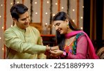 Small photo of Indian sister tying rakhi on her brother's wrist and expressing the love - Raksha Bandhan, Indian Model. Loving sister ties a sacred thread embellished with her love and affection towards the broth...