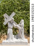 Small photo of Santa Inez, CA, USA - April 3, 2009: San Lorenzo Seminary. Station of the Cross number 8 white marble statue. Jesus meets women of Jerusalem. Green foliage in back.