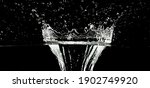 Small photo of beautiful water plop with water drops isolatet on black background, water splash texture black and white close-up
