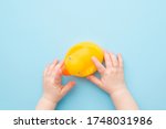 Baby hands touching yellow rubber duckling on light blue table background. Pastel color. Closeup. Bathing toy for little kids. Point of view shot.