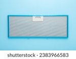 New clean kitchen cooker hood filter on light blue table background. Pastel color. Closeup. Top view.