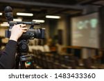 Camera man recording event with professional video camera Panasonic. Blurred background