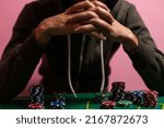 Small photo of Unfortunate young man feeling sad, desperate and stressed after losing his money playing poker and blackjack in a nightly casino. copy space