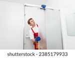 Small photo of Plumber using silicone cartridge for fixing aluminum batten of shower cabin